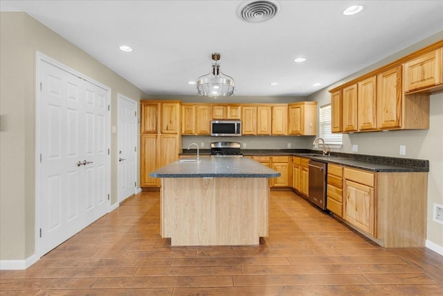 kitchen featuring light wood-type flooring, visible vents, appliances with stainless steel finishes, and a sink