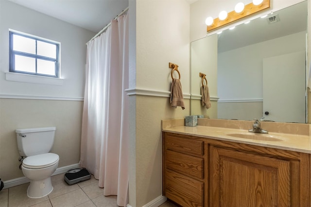 bathroom with baseboards, visible vents, toilet, tile patterned floors, and vanity