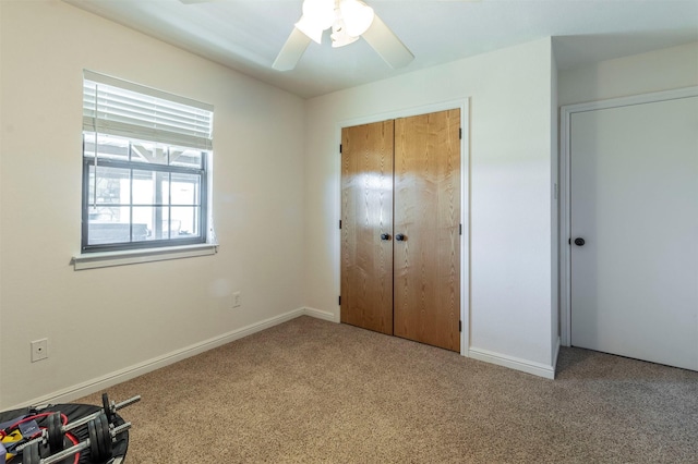 unfurnished bedroom featuring ceiling fan, a closet, carpet flooring, and baseboards