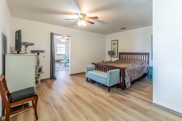 bedroom with light wood-style flooring, visible vents, ceiling fan, and baseboards