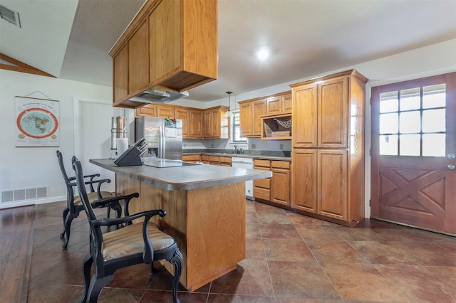 kitchen with white dishwasher, visible vents, a kitchen breakfast bar, stainless steel fridge with ice dispenser, and brown cabinets