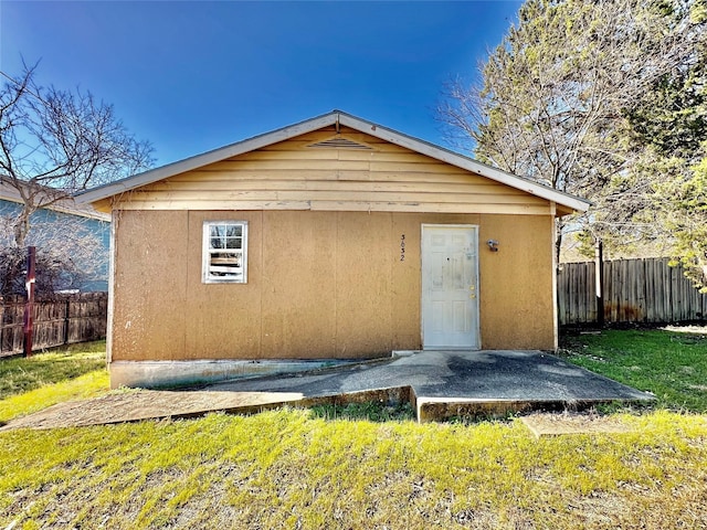 exterior space featuring a lawn, fence, and stucco siding