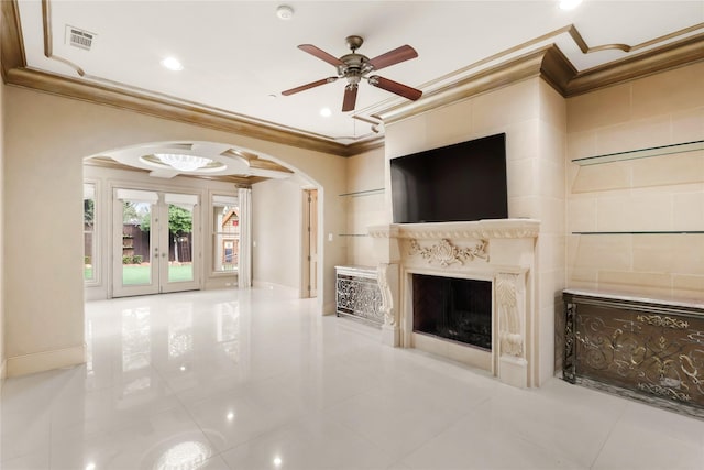 unfurnished living room featuring visible vents, arched walkways, a ceiling fan, crown molding, and a fireplace