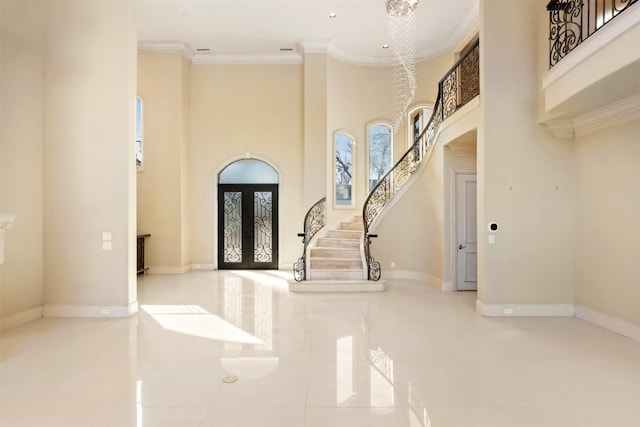 foyer entrance with stairs, french doors, a towering ceiling, and crown molding