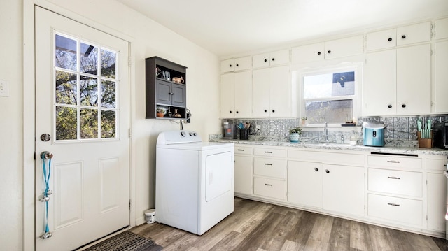 laundry room with cabinet space, washer / clothes dryer, a sink, and wood finished floors