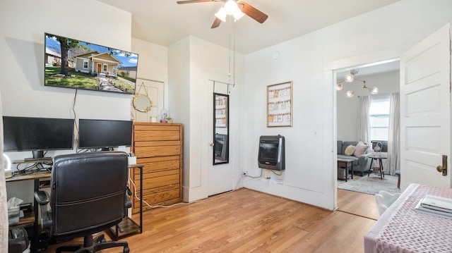 home office with light wood-type flooring, a ceiling fan, and heating unit