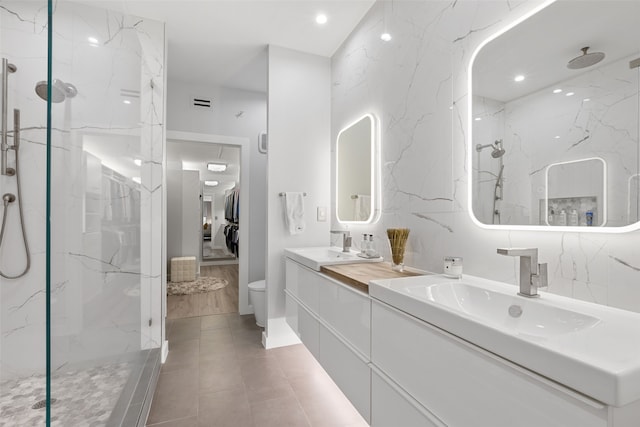 bathroom featuring a sink, double vanity, and a marble finish shower