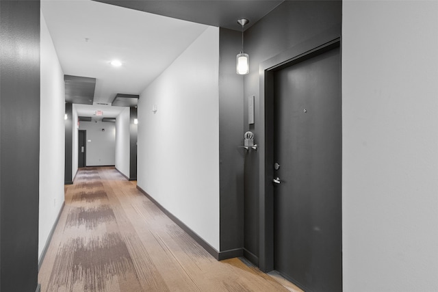 hall with light wood finished floors and baseboards