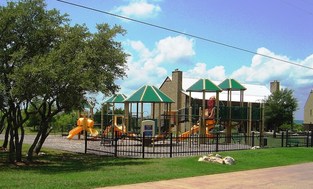 community jungle gym featuring fence and a lawn