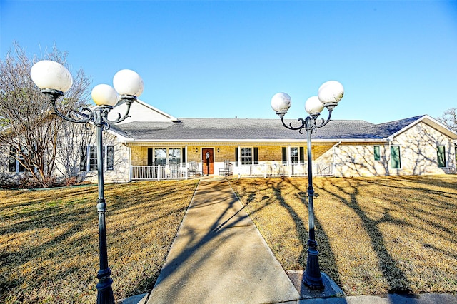 ranch-style home featuring stone siding, a porch, and a front yard