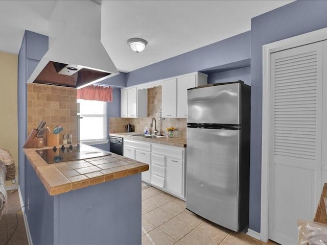 kitchen featuring a sink, exhaust hood, white cabinetry, black appliances, and tasteful backsplash