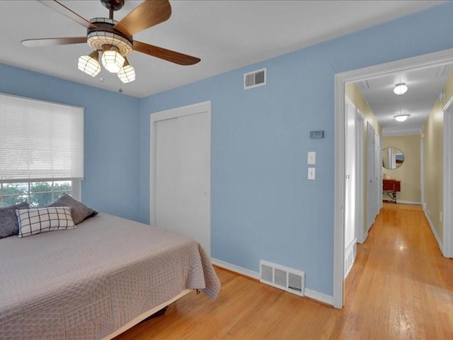 bedroom featuring visible vents, a closet, and wood finished floors