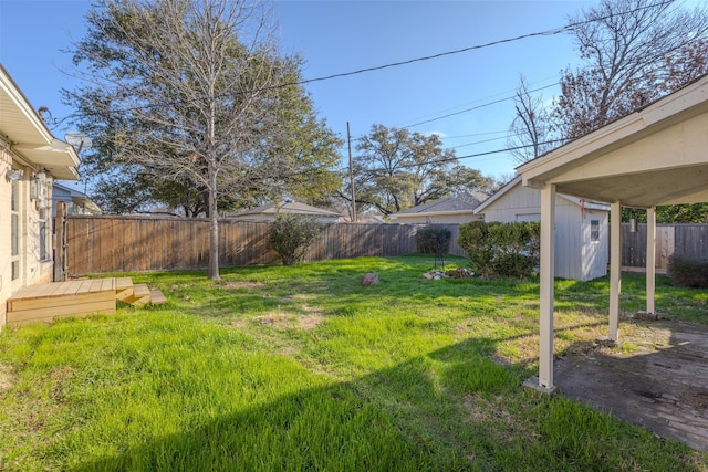 view of yard with an outdoor structure, a fenced backyard, and a wooden deck