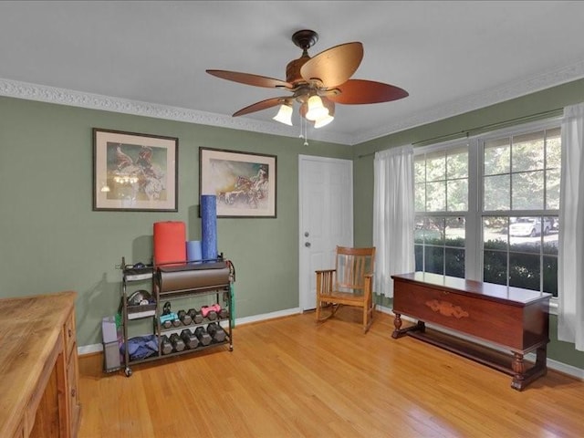 sitting room with crown molding, baseboards, ceiling fan, and light wood finished floors