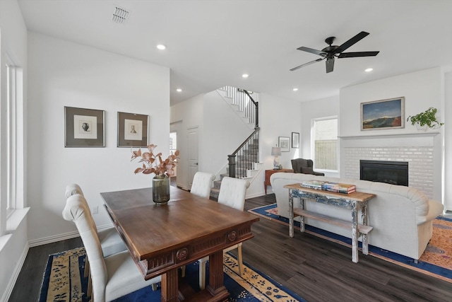 dining space featuring a fireplace, stairway, dark wood-type flooring, and recessed lighting