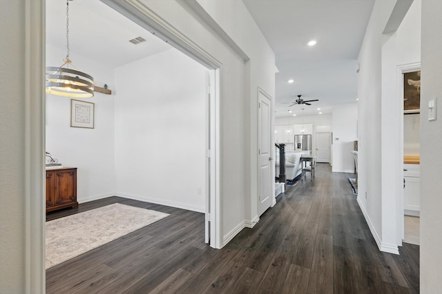 corridor featuring baseboards, visible vents, dark wood finished floors, and recessed lighting