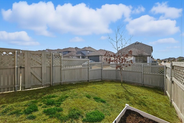 view of yard featuring a residential view, a gate, and a fenced backyard