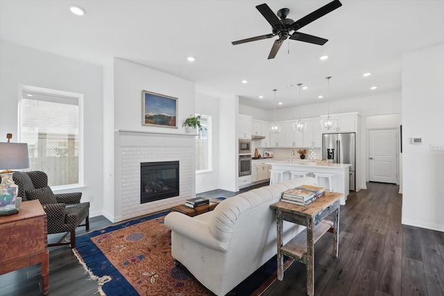 living area with recessed lighting, dark wood-style flooring, and baseboards