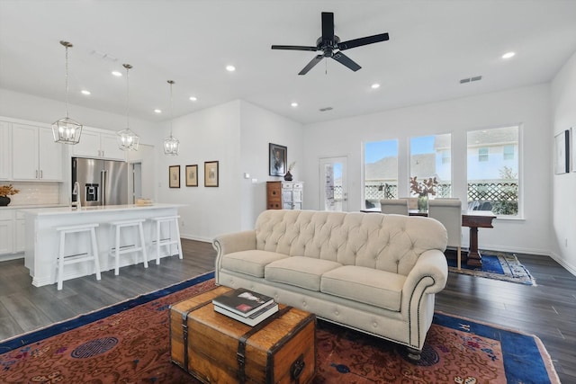 living area with dark wood-style floors, recessed lighting, visible vents, and baseboards