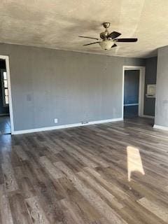 unfurnished living room featuring a ceiling fan, dark wood finished floors, and baseboards