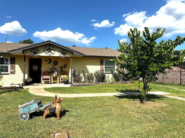 view of front of property featuring fence, a front lawn, and brick siding