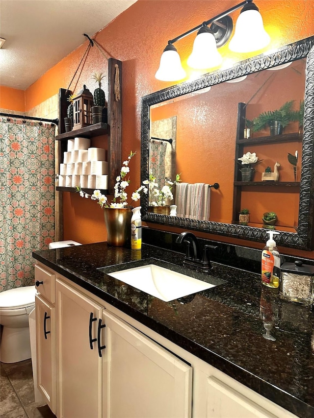 bathroom featuring a shower with shower curtain, vanity, toilet, and a textured ceiling