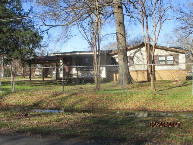 exterior space featuring a lawn and fence