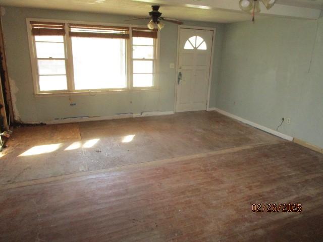 foyer entrance featuring ceiling fan and baseboards