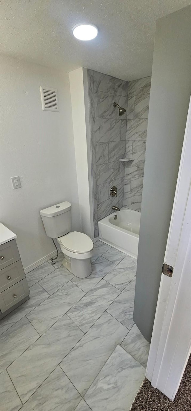 bathroom with toilet, marble finish floor, visible vents, and a textured ceiling