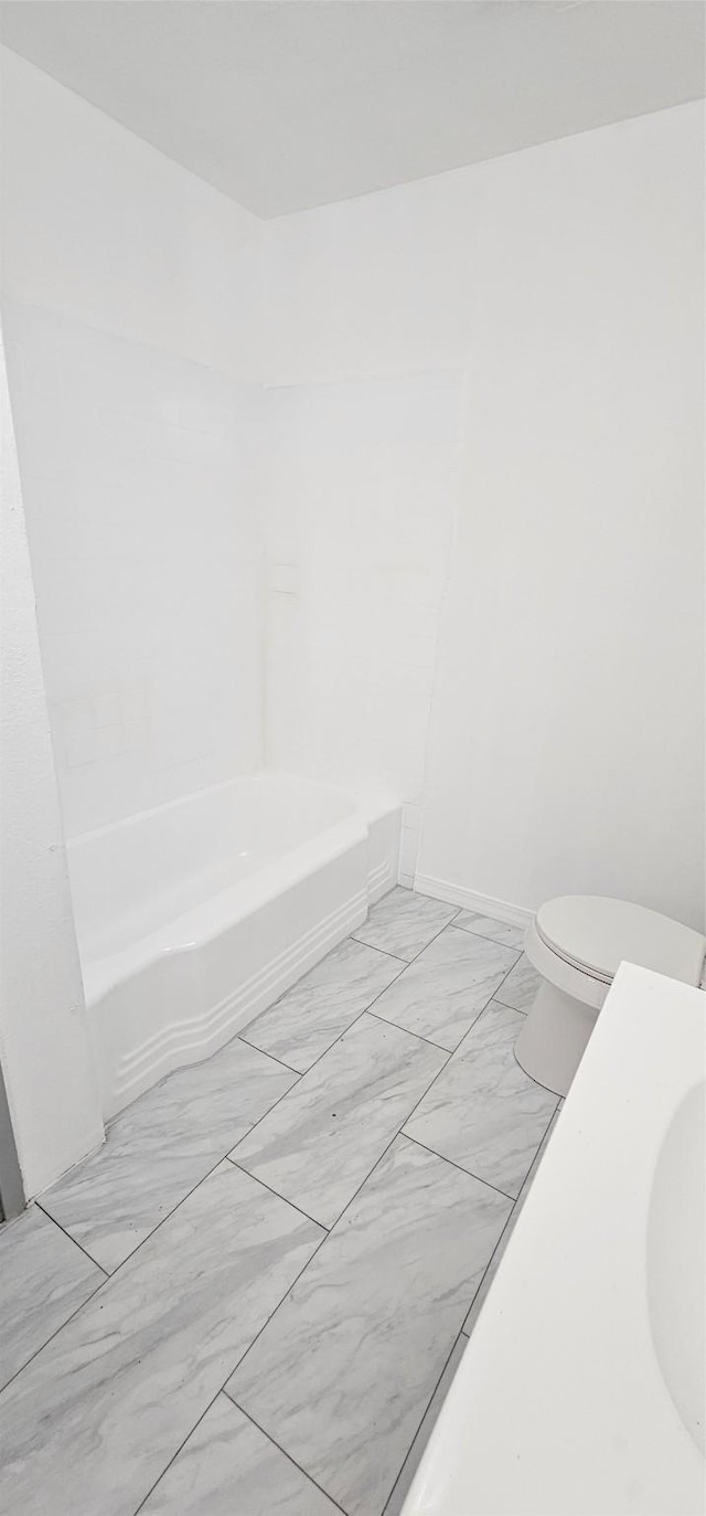 full bathroom with marble finish floor and toilet