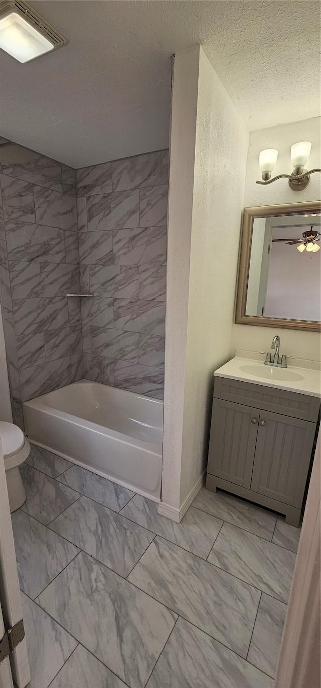 full bathroom with toilet, marble finish floor, a textured ceiling, and vanity