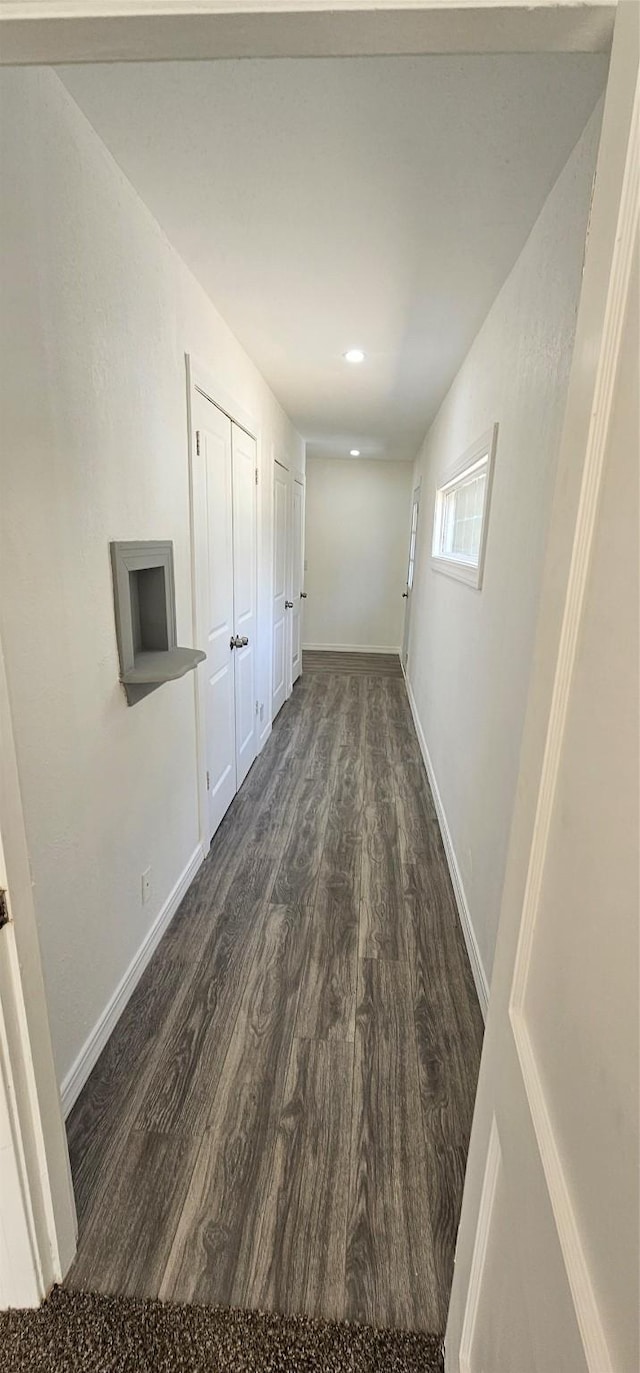 corridor with recessed lighting, dark wood-style flooring, and baseboards