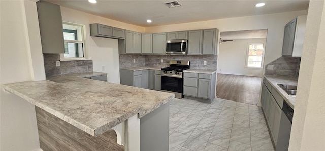 kitchen featuring marble finish floor, stainless steel appliances, visible vents, and gray cabinetry