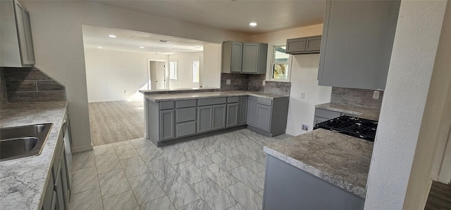 kitchen with recessed lighting, a sink, gray cabinets, range, and decorative backsplash