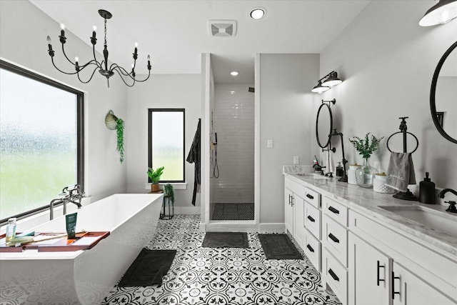 bathroom with double vanity, a freestanding bath, a sink, a shower stall, and tile patterned flooring