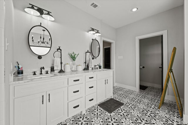 full bath with double vanity, baseboards, visible vents, and a sink