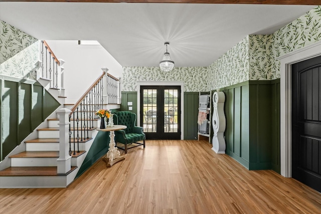 interior space featuring wallpapered walls, stairway, wood finished floors, and french doors