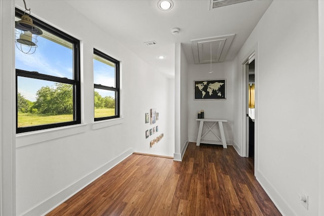 corridor with attic access, baseboards, visible vents, dark wood-type flooring, and recessed lighting