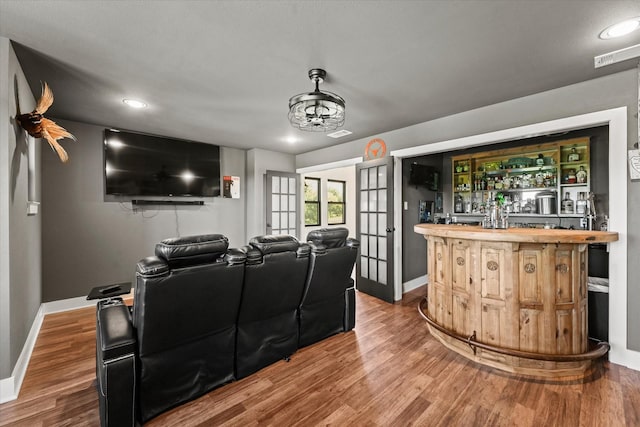 cinema room with recessed lighting, baseboards, a dry bar, and wood finished floors