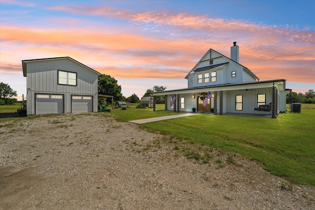 modern farmhouse featuring driveway, a lawn, covered porch, central air condition unit, and board and batten siding