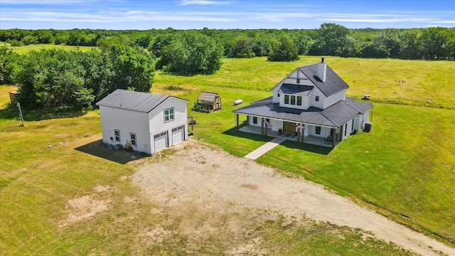 drone / aerial view featuring a wooded view