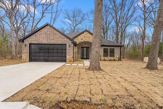 view of front of property with a shingled roof, concrete driveway, stone siding, an attached garage, and brick siding