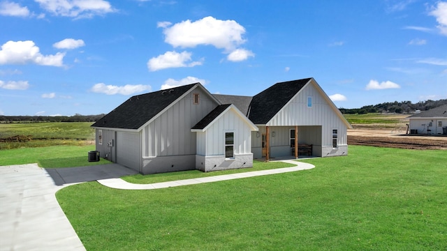 modern farmhouse style home with board and batten siding, a front yard, concrete driveway, and a garage