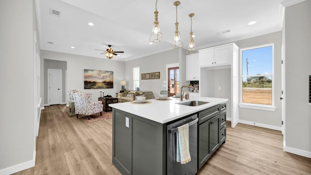 kitchen featuring visible vents, dishwasher, light countertops, white cabinetry, and a sink