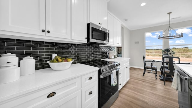 kitchen with electric stove, tasteful backsplash, stainless steel microwave, white cabinets, and light wood-type flooring