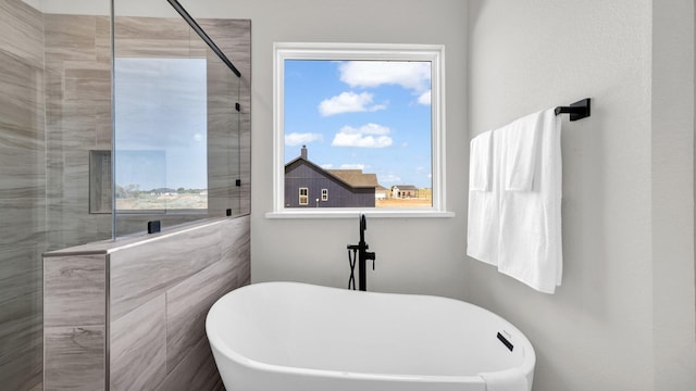 full bathroom with a walk in shower and a freestanding tub