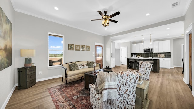 living area with recessed lighting, visible vents, baseboards, ornamental molding, and light wood-type flooring