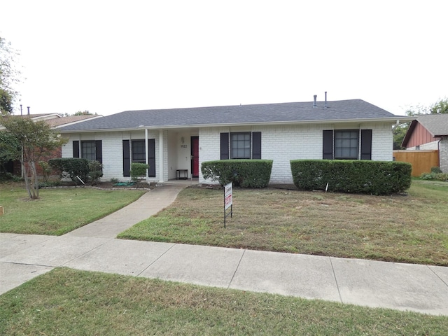 single story home with roof with shingles, brick siding, and a front lawn