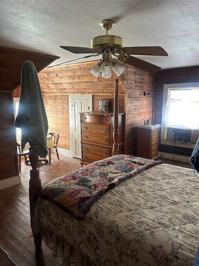 bedroom with wooden walls, ceiling fan, wood finished floors, cooling unit, and a textured ceiling