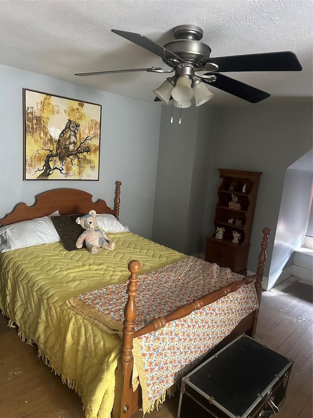 bedroom with wood-type flooring, ceiling fan, and a textured ceiling